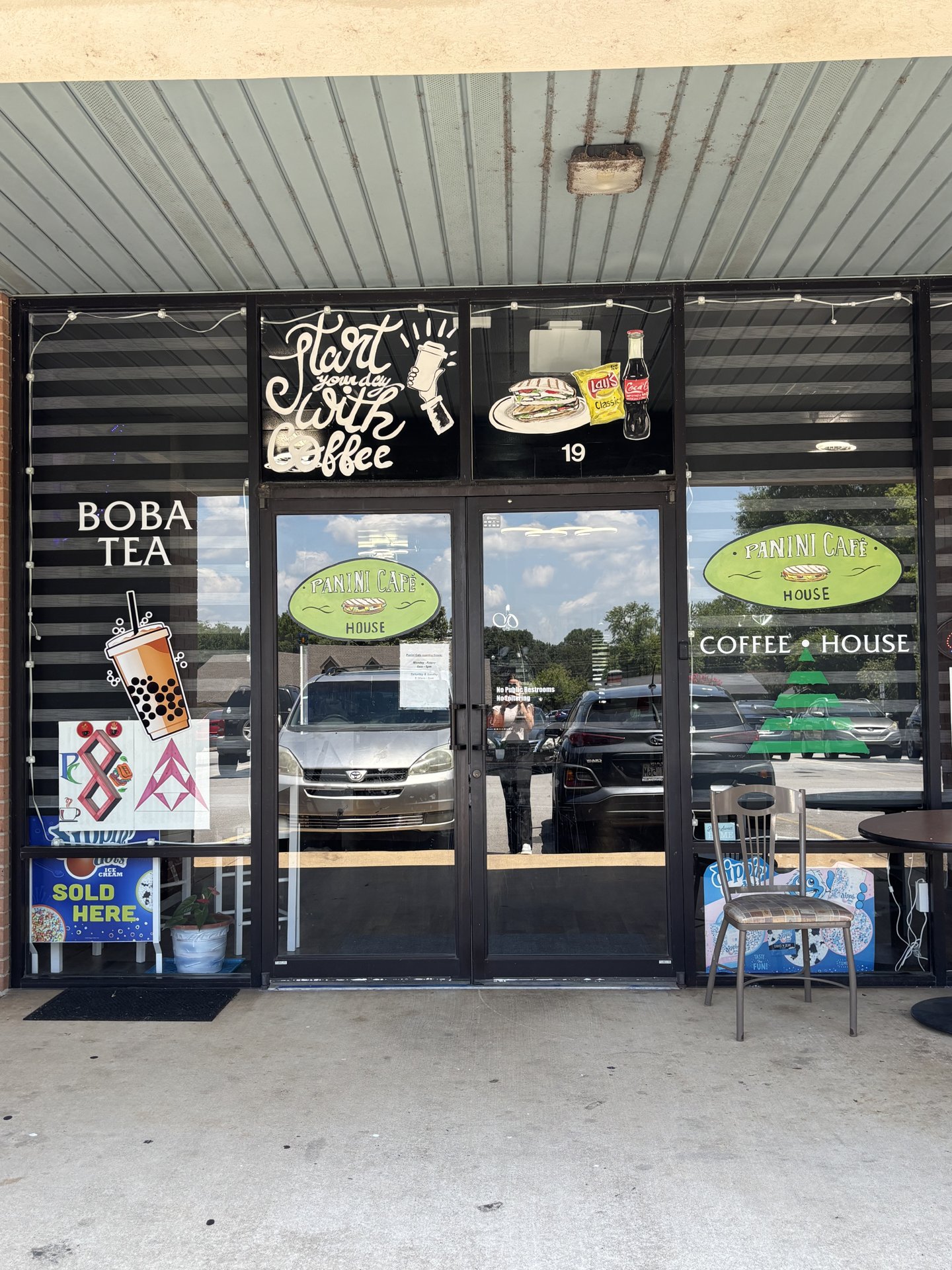 Storefront of Panini Coffee House with the Panini Café sign and 'Start your day with coffee' window art